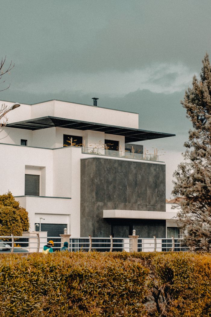Services Contemporary house facade with geometric design elements and landscaping.