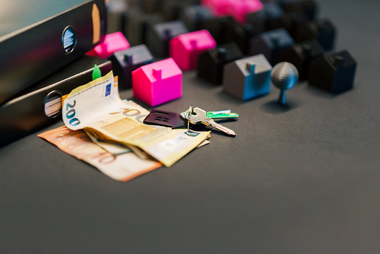 Services Miniature houses, euro bills, and a house key symbolize real estate investment and property transactions.